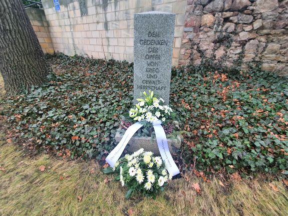 Blumengebinde am Gedenkstein Karrasburg
