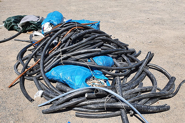 Haufen mit illegal entsorgter Kabelisolation, teilweise in blauen Säcken