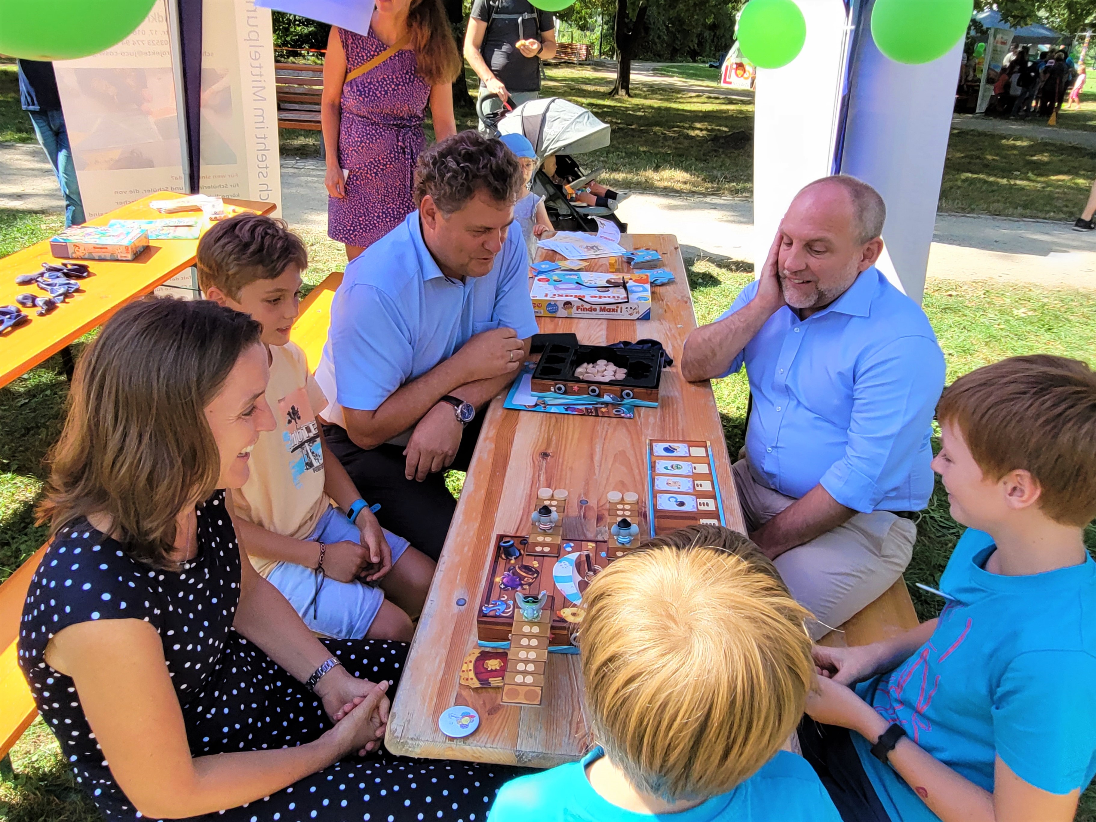 Drei Erwachsene und drei Kinder beim Brettspiel