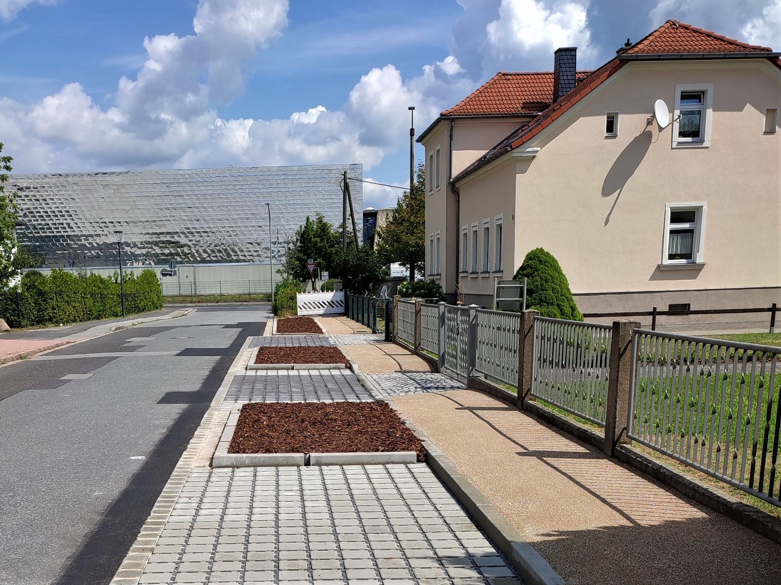 Wettinstraße, erster Bauabschnitt Juli 2023. Bauminseln noch unbefpflanzt. Parkbuchten gepflastert.