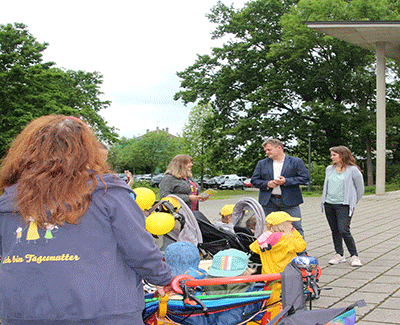 Kinder und Tagesmütter zusammen mit Oberbürgermeister vor dem Rathaus