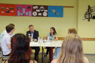 Jugendliche sitzen mit Oberbürgermeister am Tisch