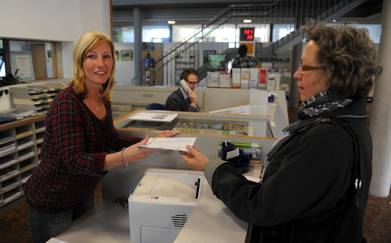 Mitarbeiterin des Bürgerbüros und Bürgerin am Empfangstresen des Rathauses