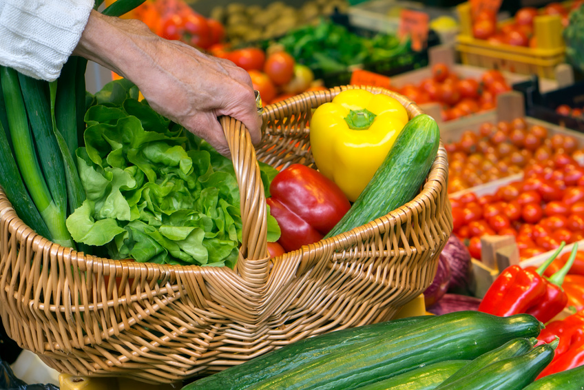 Symbolfoto Einkaufen - Hand hält Korb mit Gemüse