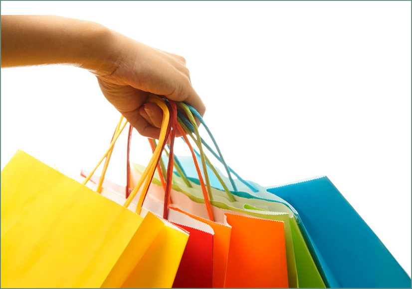 Symbolbild Einkaufen - Hand mit Papiereinkaufstüten